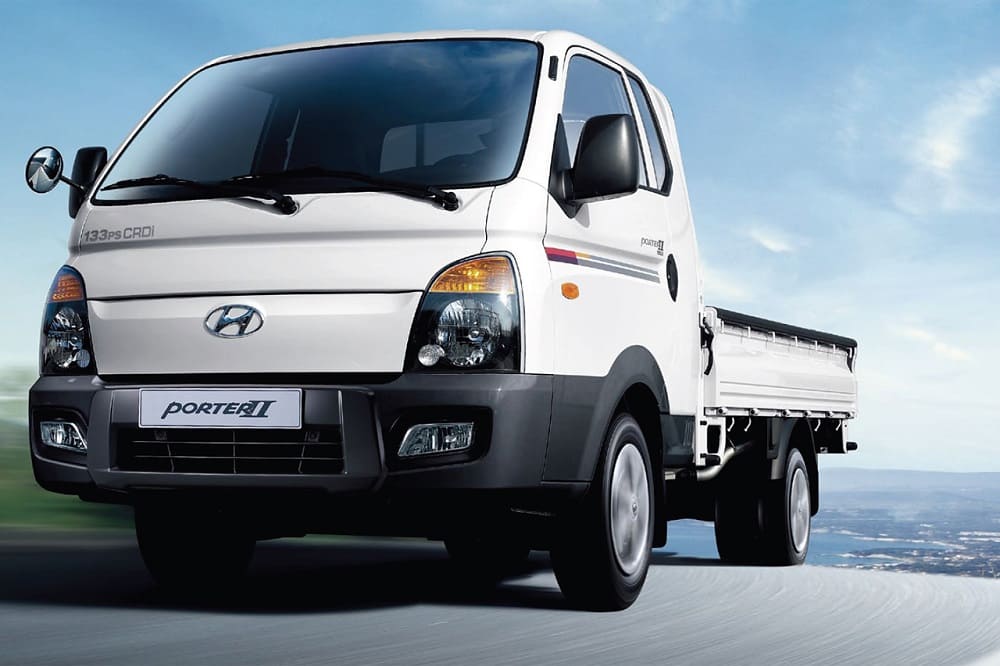 Белый Hyundai Porter едет по дороге